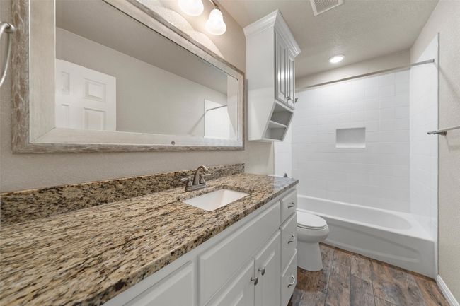 Full bathroom with wood finished floors, vanity, and bathtub / shower combination | Image 14