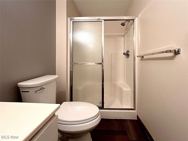 Master bathroom with a shower stall, wood finished floors, vanity, and a textured ceiling | Image 12