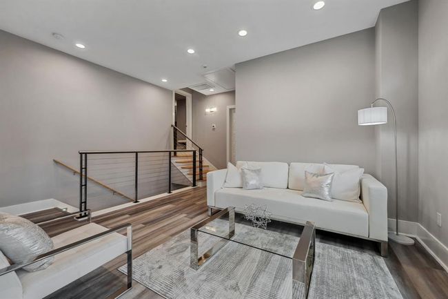 The second-floor game room offers a warm and welcoming ambiance, while the custom staircase railing adds a unique and sophisticated charm. | Image 35