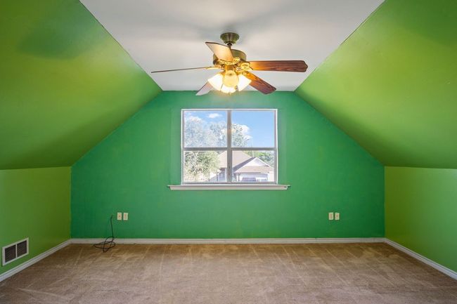 Additional living space featuring carpet floors, a ceiling fan, and vaulted ceiling | Image 21