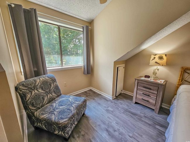 Sitting room with wood finished floors, baseboards, and a textured ceiling | Image 22