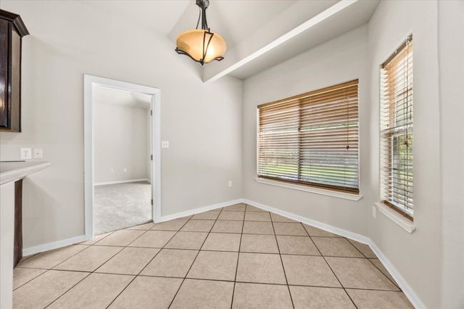 Unfurnished dining area featuring light tile patterned flooring, plenty of natural light, and baseboards | Image 11