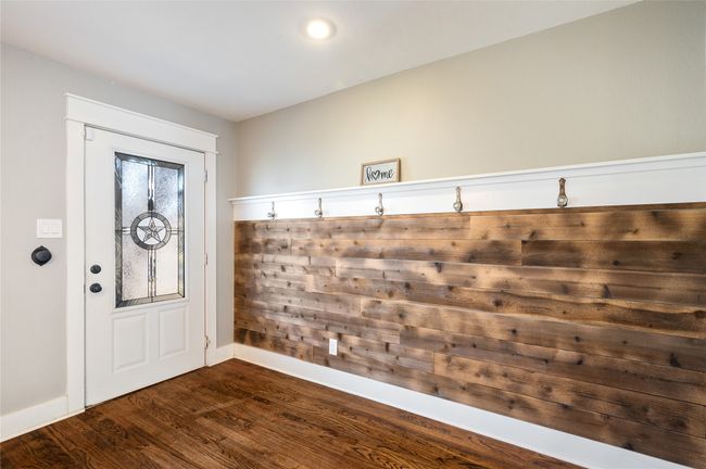 Custom wood wall with original 1942 crystal door knobs repurposed as coat hooks at the entry | Image 6
