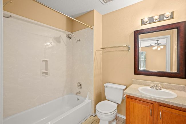 Bathroom featuring shower / bath combination, vanity, toilet, and tile patterned floors | Image 13
