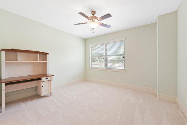 Well-sized secondary bedroom with fresh carpet, ceiling fan, and a large window for natural light. Includes a built-in desk—ideal for homework, remote work, or creative projects. | Image 36