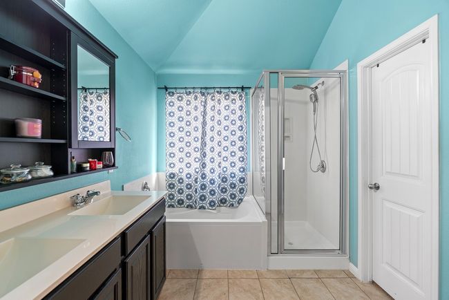 Bathroom featuring a shower stall, a sink, a bath, lofted ceiling, and tile patterned flooring | Image 8