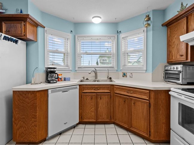 The sink has views out to the water and boat house. | Image 12