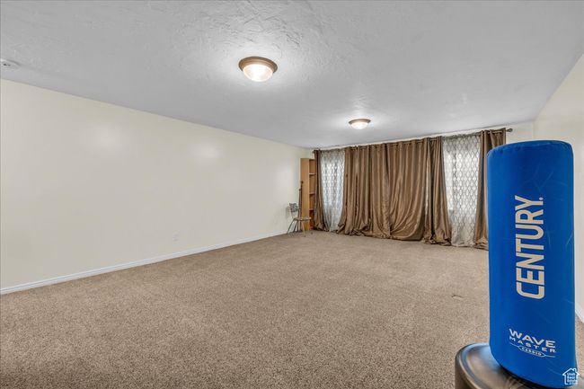 Interior space with a textured ceiling, carpet, and baseboards | Image 12