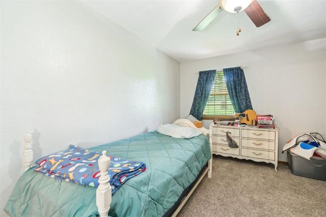 Carpeted bedroom with a ceiling fan | Image 26