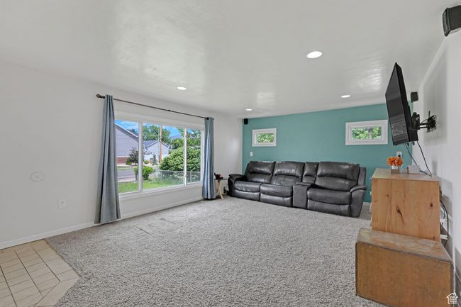 Carpeted living area featuring recessed lighting, tile patterned flooring, and baseboards | Image 6