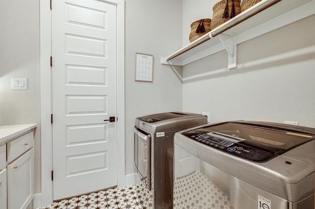 Adorable tile floor in this laundry room with counter and sink area conveniently connects directly to the closet of the primary suite. | Image 33
