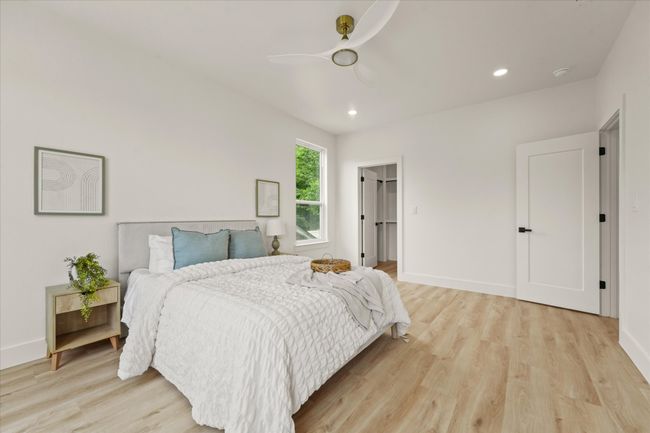 Bedroom with light wood-style floors, a ceiling fan, recessed lighting, baseboards, and a walk in closet | Image 13