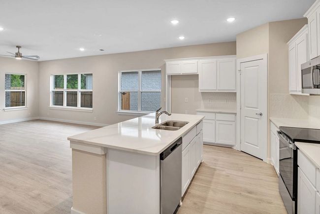 Kitchen featuring appliances with stainless steel finishes, light wood-style flooring, a ceiling fan, recessed lighting, and backsplash | Image 4