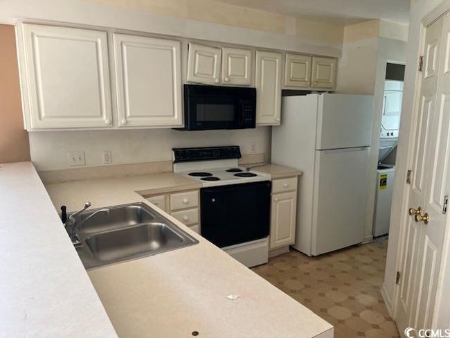 Kitchen with white appliances, light floors, light countertops, and white cabinetry | Image 5