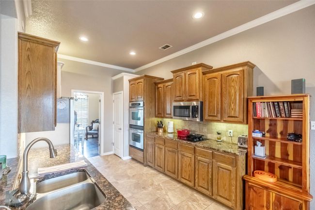 Kitchen with a sink, appliances with stainless steel finishes, crown molding, tasteful backsplash, and recessed lighting | Image 8