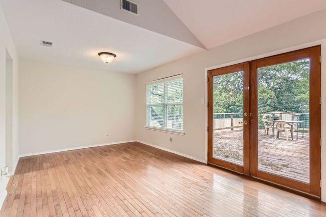 Doorway with visible vents, light wood finished floors, vaulted ceiling, and french doors | Image 7