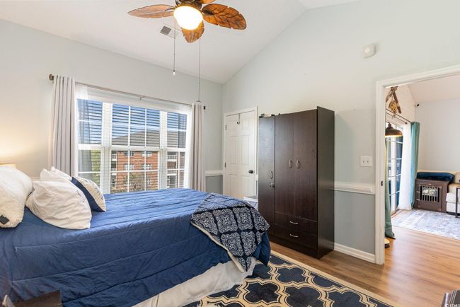 Bedroom with ceiling fan, wood finished floors, baseboards, and high vaulted ceiling | Image 12