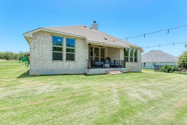 The back of 104 Black Talon reveals 100% masonry construction. This home is surround by a sprinkler system. | Image 19