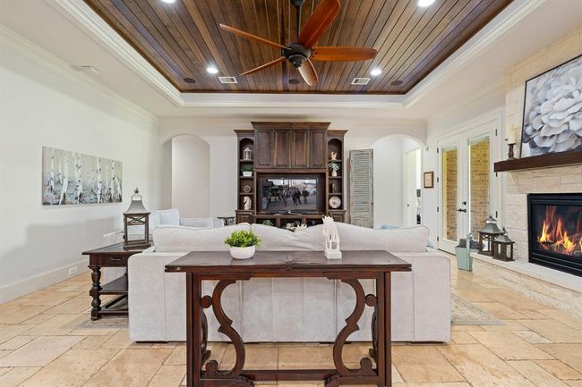 With the Primary Bedroom through the arched walkway to the right, and three Secondary Bedrooms located through the archway to the left, all accommodations reconvene in this spacious and centrally located Living Room. | Image 10