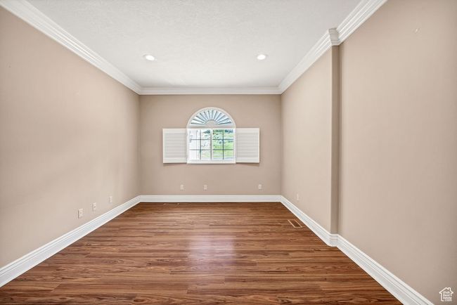 Unfurnished room with crown molding, baseboards, wood finished floors, and recessed lighting | Image 23