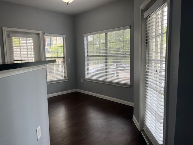 Spare room featuring baseboards, dark wood-type flooring, and a healthy amount of sunlight | Image 8