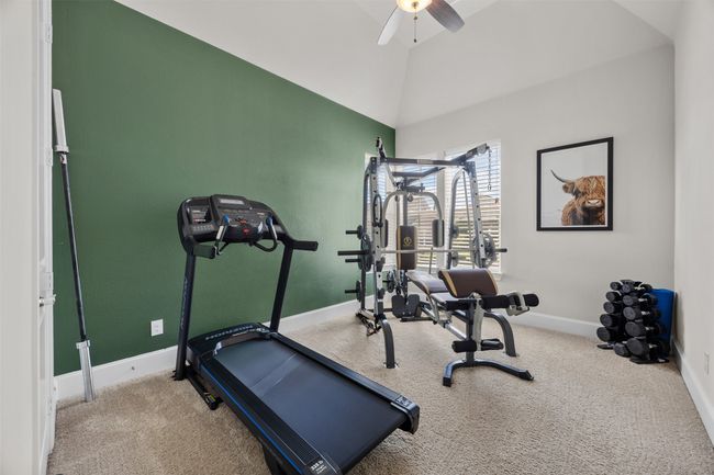 Exercise area with carpet floors, ceiling fan, and lofted ceiling | Image 25