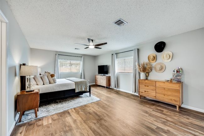 Bedroom featuring wood finished floors, a textured ceiling, baseboards, and ceiling fan | Image 20