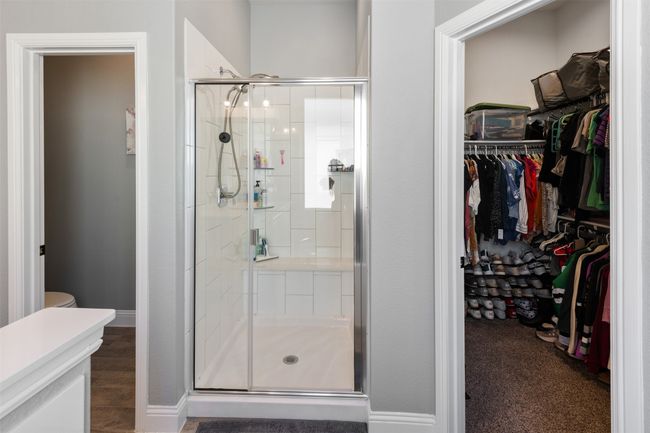 Full bath with a stall shower, a spacious closet, and baseboards | Image 25