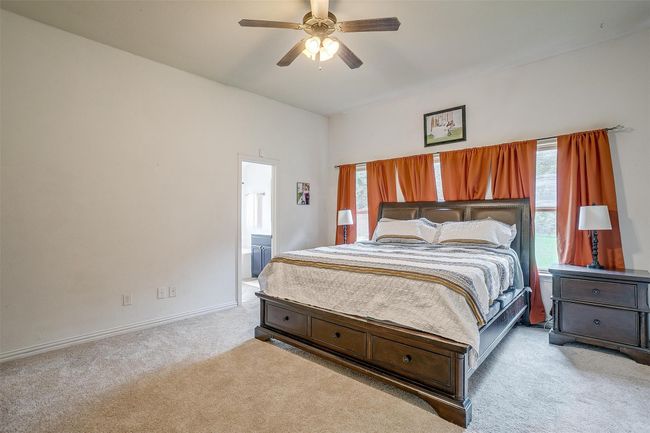 Bedroom with carpet floors, ceiling fan, and connected bathroom | Image 19