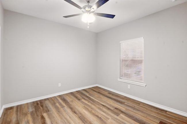 Empty room with ceiling fan, baseboards, and wood finished floors | Image 22