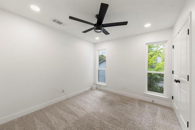 Additional bedroom (1) located upstairs features plush carpet, nice natural light, ceiling fan, and canned lights. | Image 19