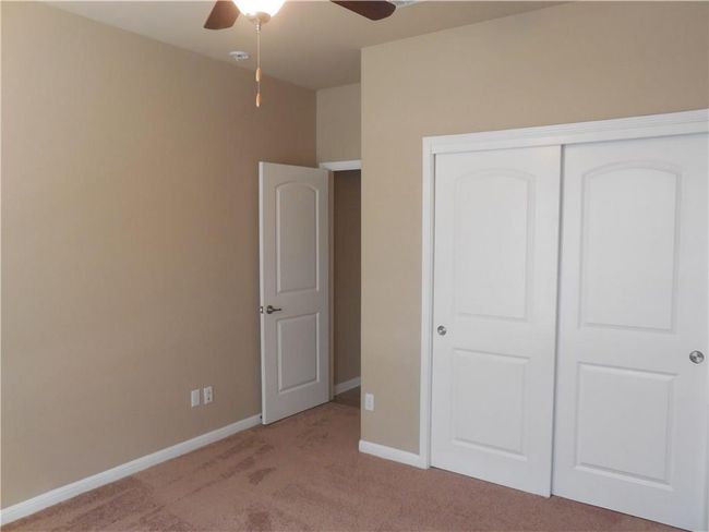Unfurnished bedroom with light colored carpet, a closet, baseboards, and a ceiling fan | Image 17