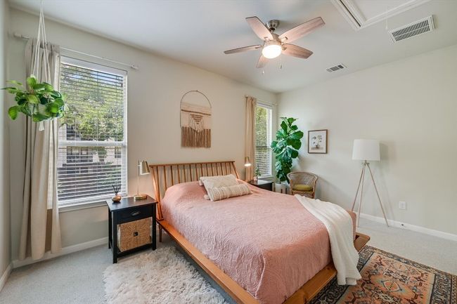 Bedroom featuring attic access, light colored carpet, baseboards, and ceiling fan | Image 21