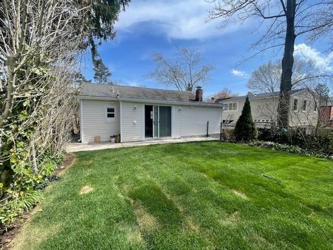 Rear view of house featuring a lawn, fence, a chimney, and a patio | Image 9