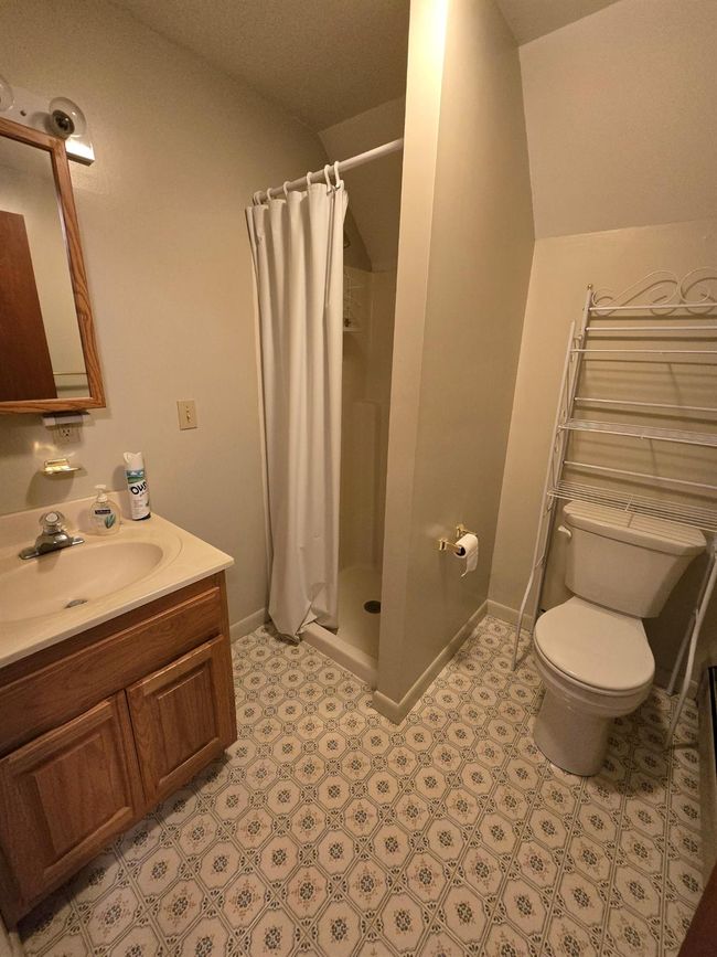 Bathroom featuring toilet, vanity, a shower stall, and baseboards | Image 9