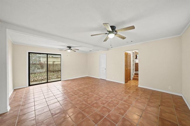 WOW! This family room is the perfect place to entertain your guests as it offers an easy access to your kitchen. This room includes tile loors, a ceiling fan, crown molding and a double glass sliding door which will give you access to your backyard. | Image 11