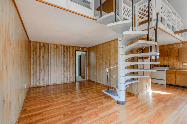 Staircase featuring ornamental molding, wooden walls, and hardwood / wood-style flooring | Image 17