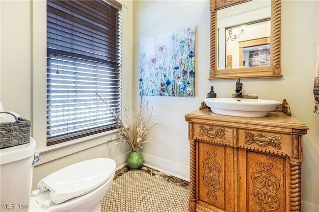 Half bathroom with toilet, baseboards, and vanity & tile flooring | Image 32