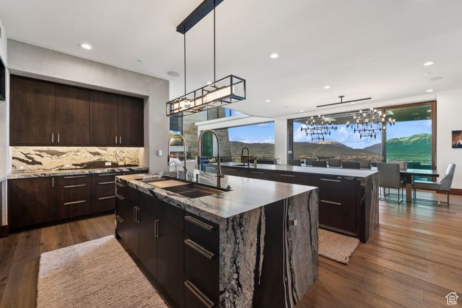 Kitchen featuring a kitchen island with sink, a chandelier, a sink, tasteful backsplash, and recessed lighting | Image 12