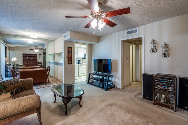 Living area featuring ceiling fan, a textured ceiling, and light carpet | Image 7