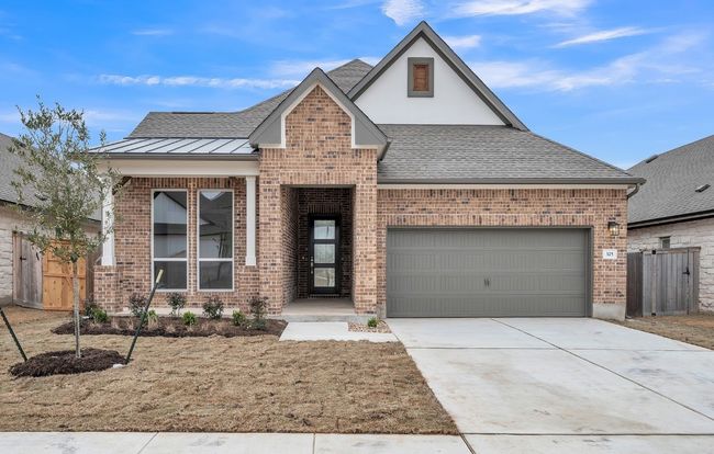 View of front facade featuring an attached garage, brick siding, concrete driveway, roof with shingles, and a standing seam roof | Image 28