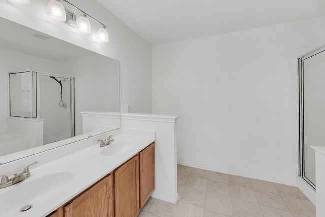 Bathroom featuring double vanity, a shower stall, marble finish floor, and a sink | Image 17