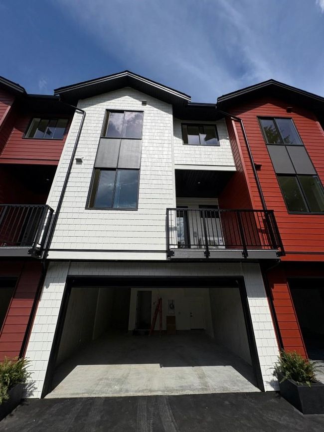 Back of house featuring a balcony, a garage, and driveway | Image 20