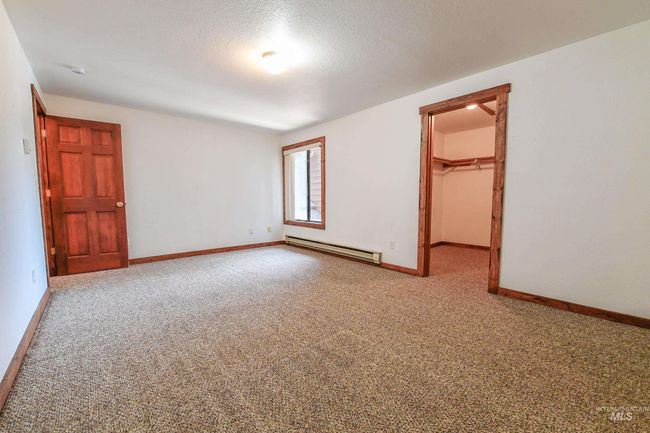 Carpeted empty room featuring a baseboard heating unit and baseboards | Image 16