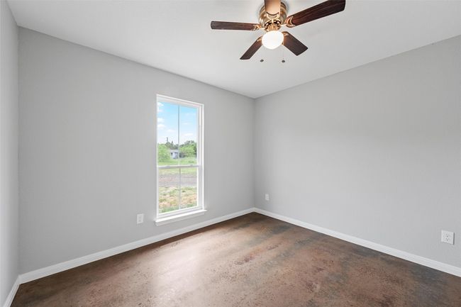 Spare room with concrete flooring, ceiling fan, and baseboards | Image 9