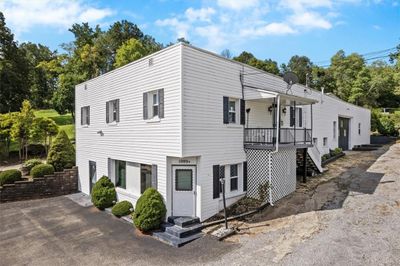 The primary building includes a commercial space on the lower level and an apartment on the upper level. The covered porch on the upper level is access to the apartment. | Image 2