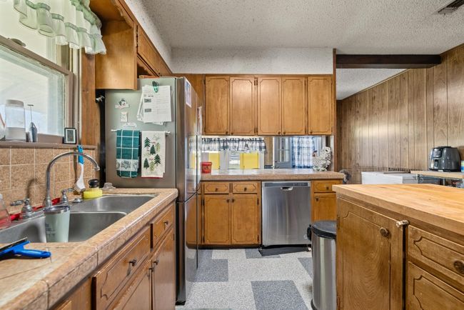 Kitchen featuring a sink, visible vents, brown cabinetry, and appliances with stainless steel finishes | Image 11