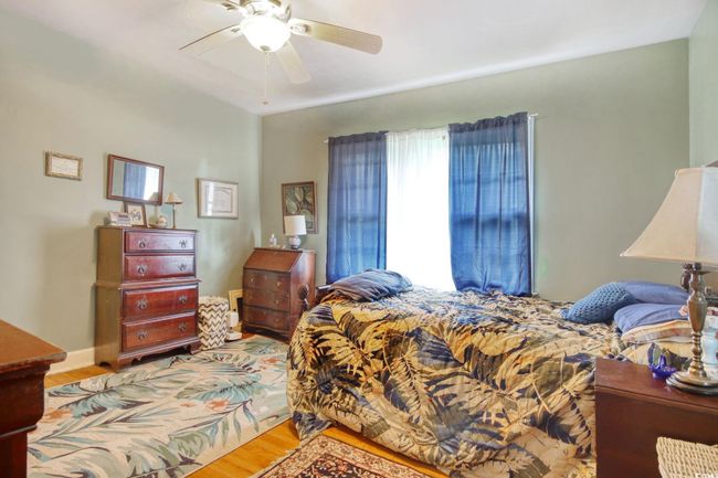 Bedroom with light wood finished floors and ceiling fan | Image 26