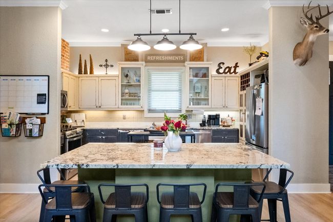Kitchen with ornamental molding, a kitchen bar, light wood finished floors, and baseboards | Image 8