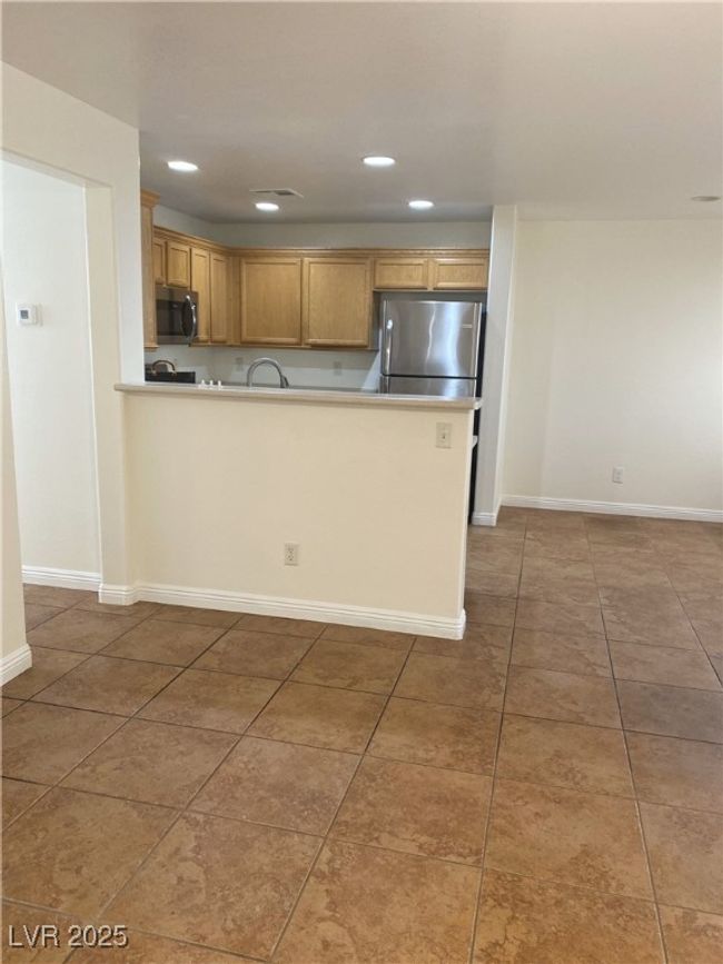 Kitchen featuring visible vents, a peninsula, light countertops, tile patterned flooring, and appliances with stainless steel finishes | Image 17